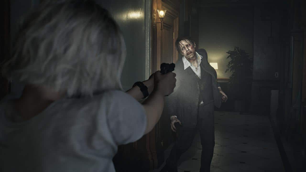 In this Resident Evil Requiem preview, a person aims a gun at a zombie lurking in a dimly lit hallway.
