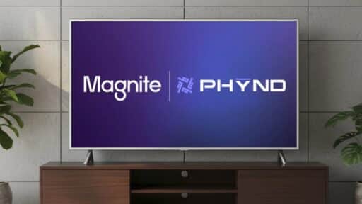 Flat-screen TV on wooden stand displaying "Magnite | PHYND" on a blue background, indoor setting.