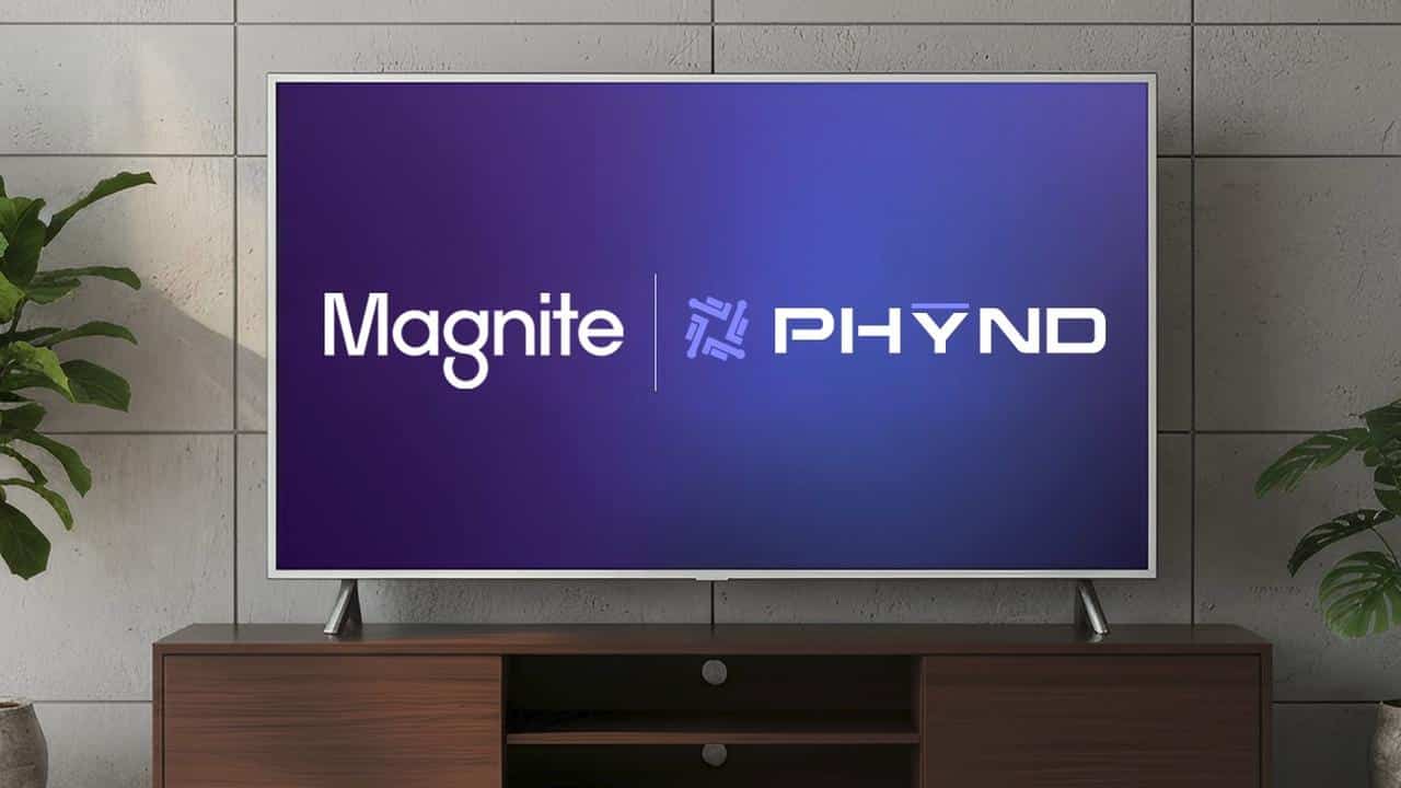 Flat-screen TV on wooden stand displaying "Magnite | PHYND" on a blue background, indoor setting.