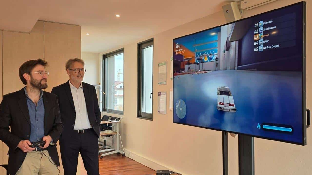 Two people testing PLEIO cloud gaming on a large TV using a controller during a Netgem demonstration