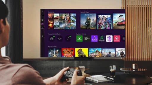 Person holding a game controller facing a TV screen displaying a gaming dashboard, showcasing various game icons—a modern look at cloud gaming distribution strategy in action.