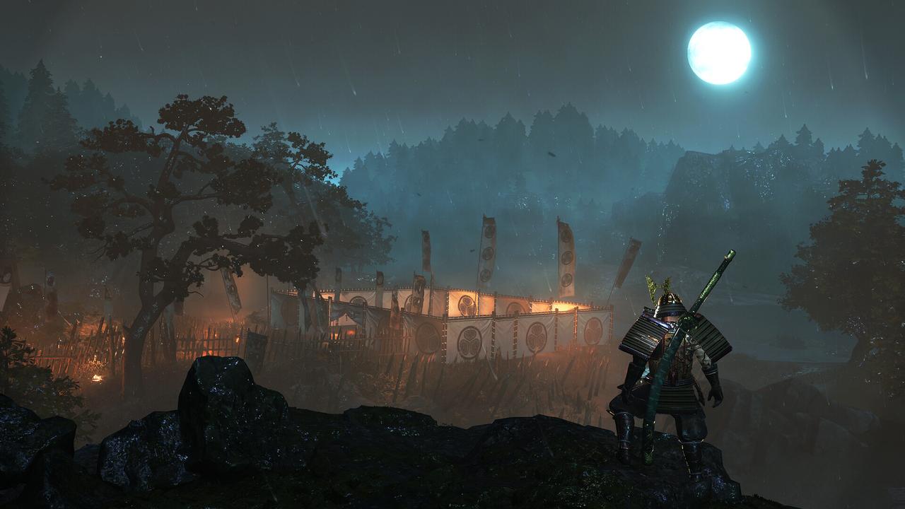A samurai overlooks a misty, moonlit camp surrounded by trees and wooden fences at night.