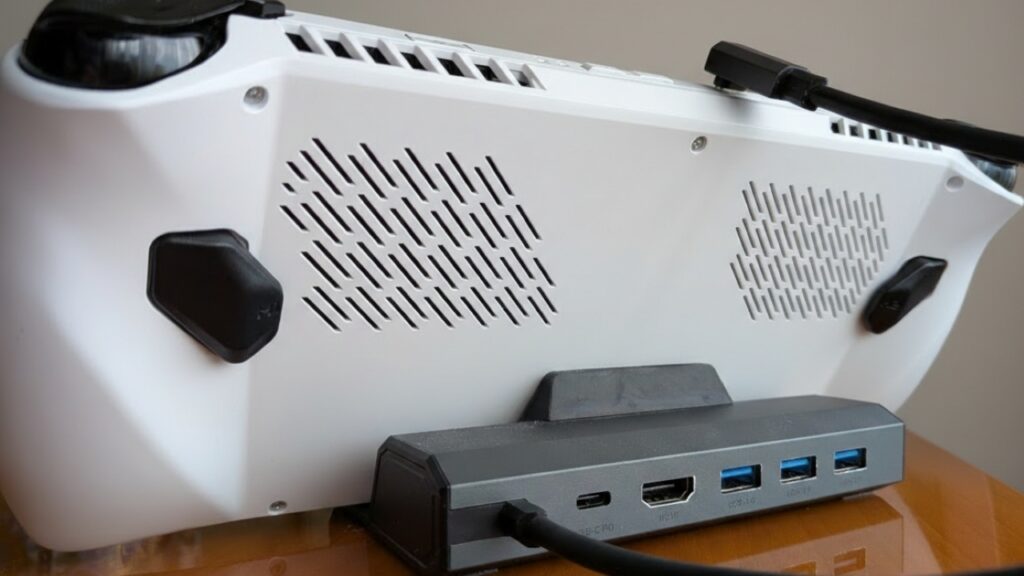 Back view of a handheld gaming device connected to a USB hub with multiple ports and cables attached.