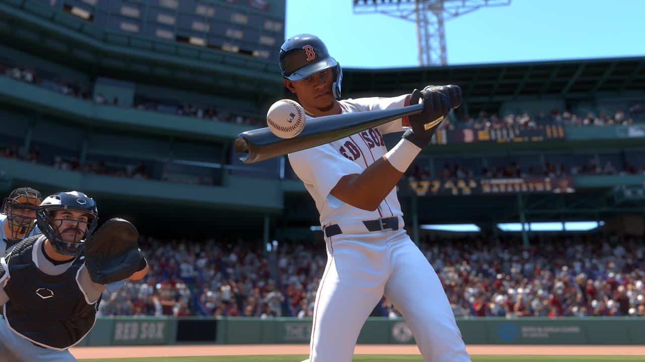 Baseball player in white uniform bunting as the ball nears the bat, just like a scene from MLB The Show 26, with a catcher and crowd in the background.