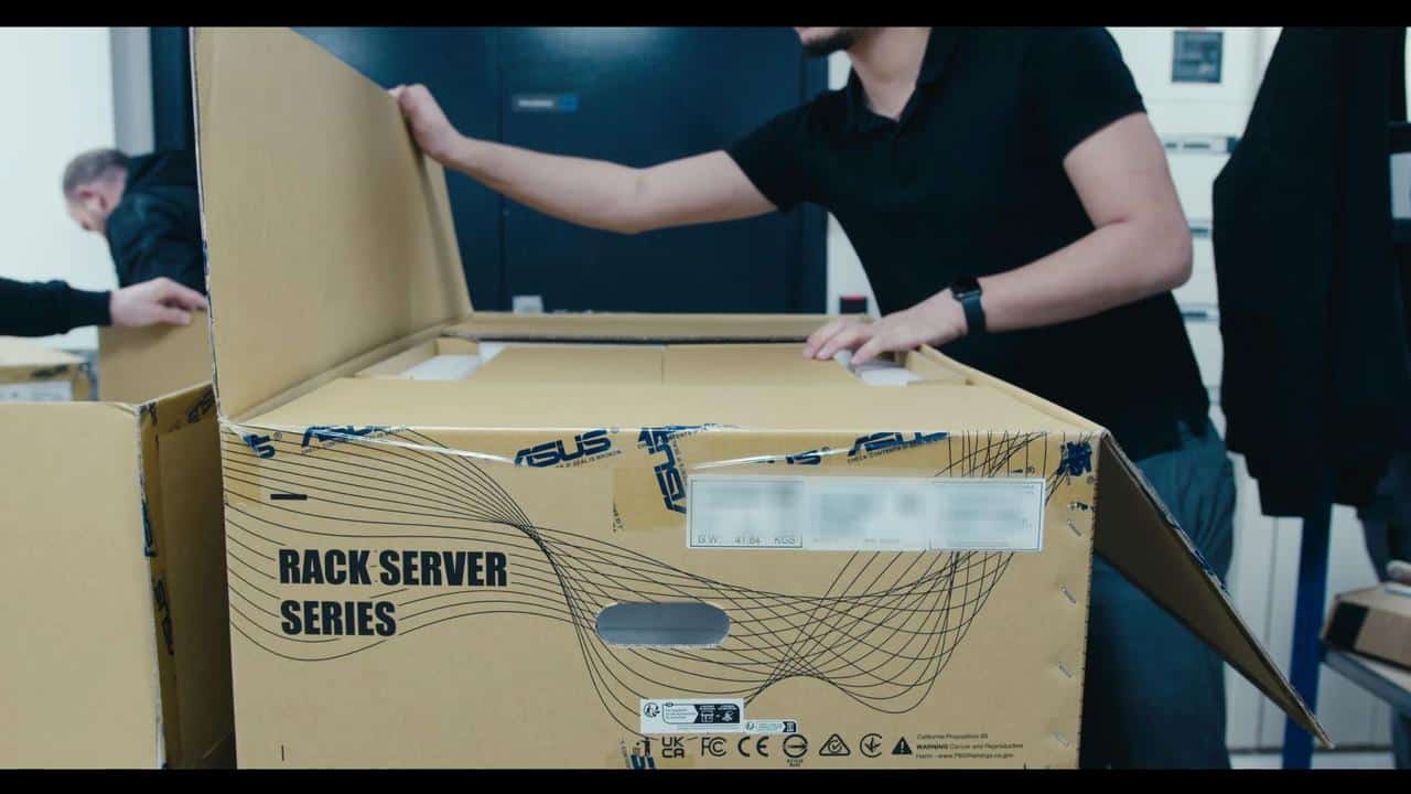 A technician opening a large ASUS Rack Server Series box during a Boosteroid infrastructure deployment.