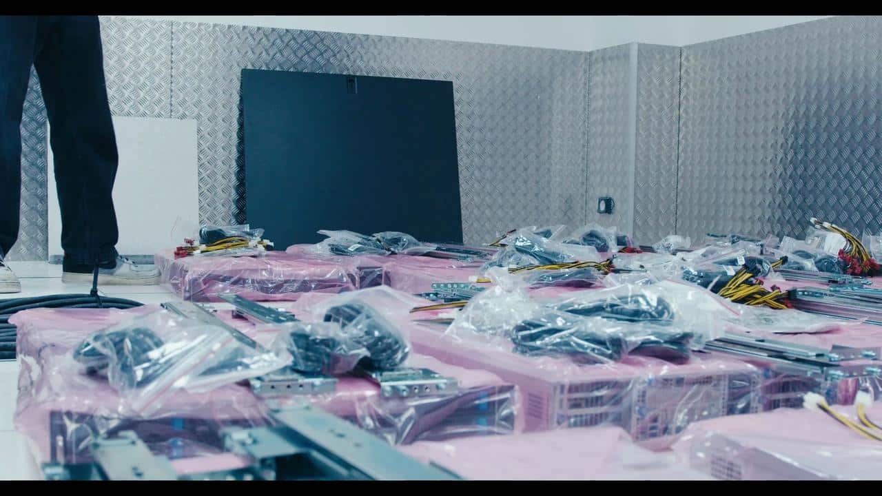 Server components, rails, and cabling laid out on the floor of a data centre room ahead of a Boosteroid infrastructure deployment.