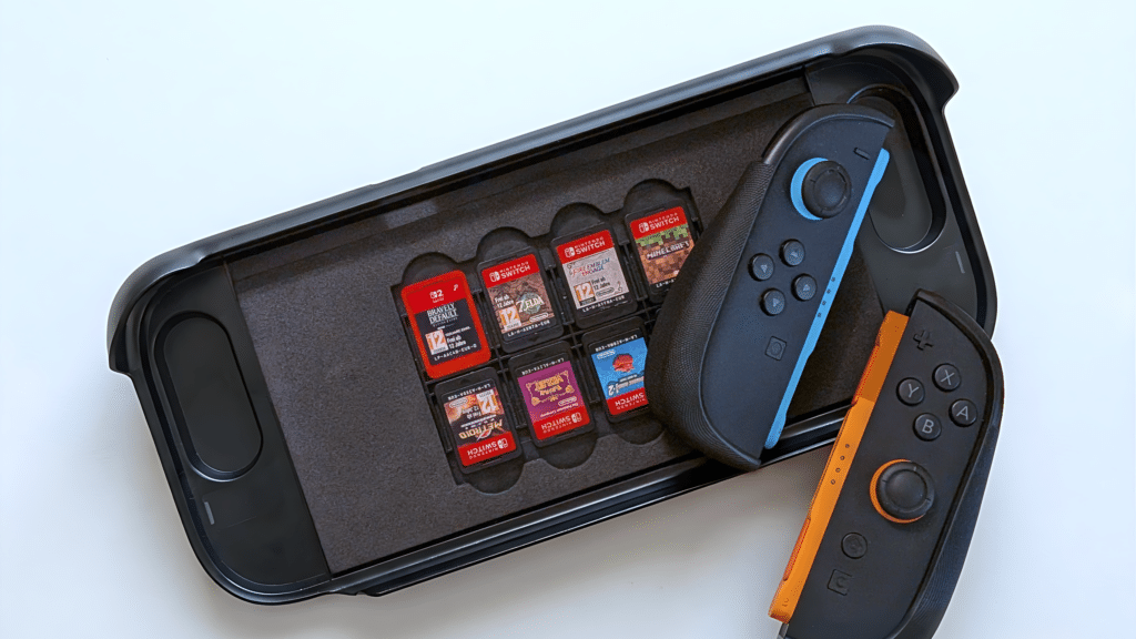 Nintendo Switch game case with six game cartridges and two detached Joy-Con controllers on a white surface.