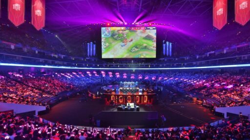 A massive esports arena filled with fans watching a competitive match on a large screen, highlighting the scale of the industry.