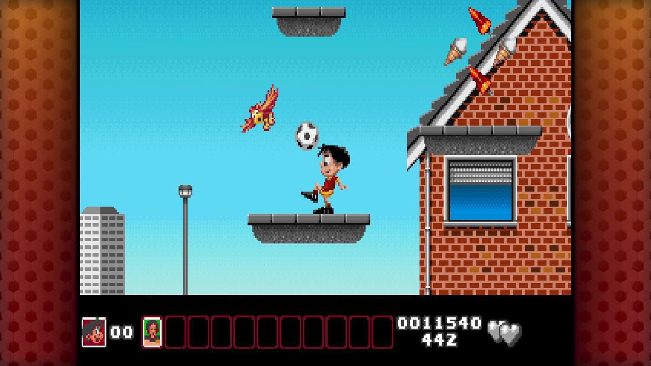 Soccer Kid jumps toward a soccer ball between floating platforms beside a brick building in Soccer Kid Collection.