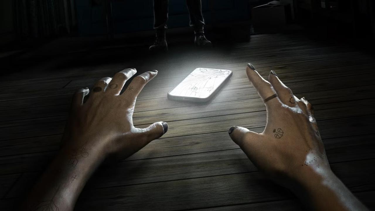 Ava reaching toward a phone during a tense scene in Netflix’s Unhinged.