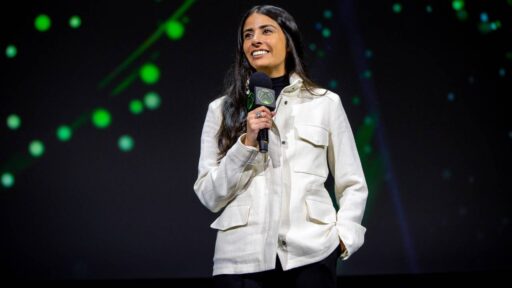 XBOX executive speaking on stage while holding an XBOX-branded microphone.