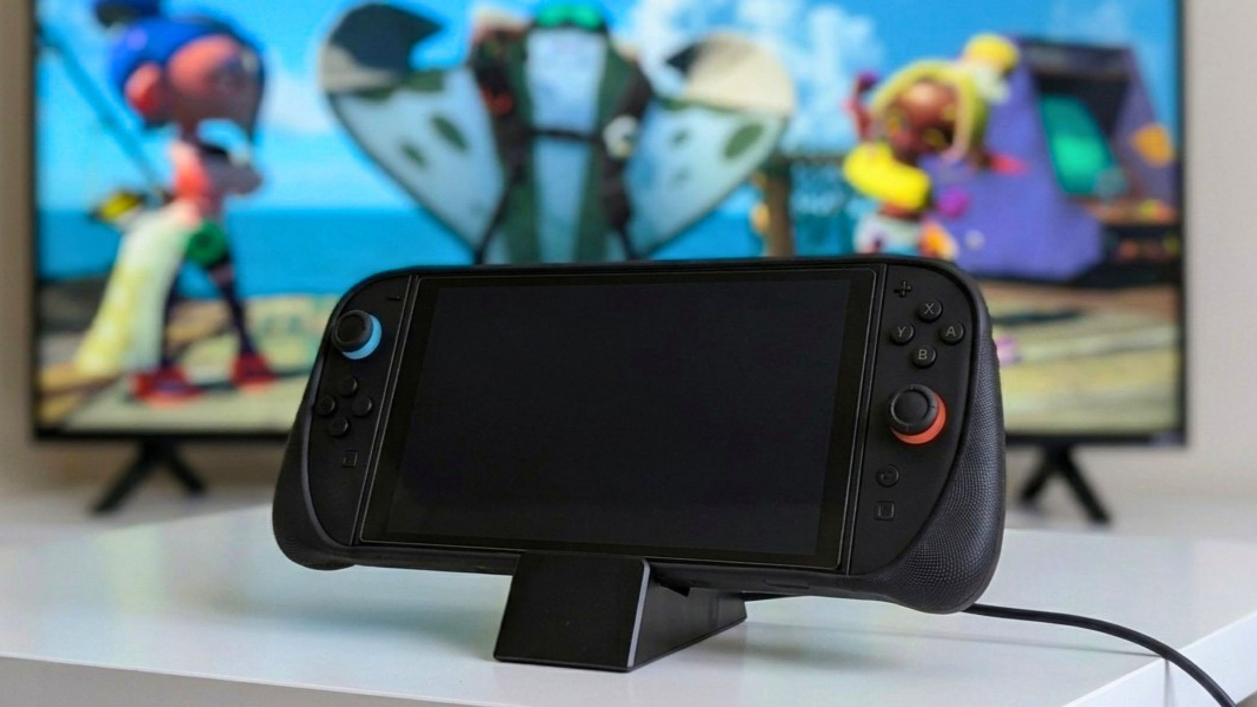 Disseny sense títol Black handheld gaming console on a stand with colorful game controllers in the background